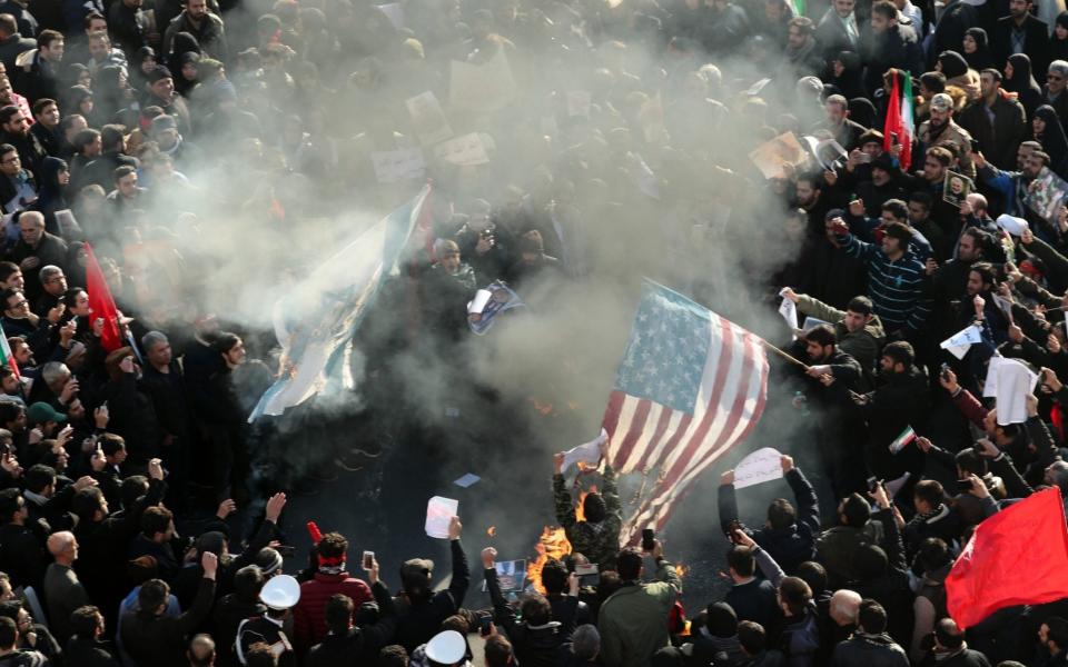 Iranians burn US and Israel flags during a funeral ceremony for slain commander of the Quds Force Qassim Suleimani - REX