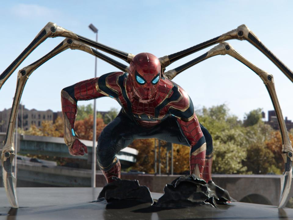 Tom Holland wearing the Spider-Man suit with iron legs in "Spider-Man: No Way Home."