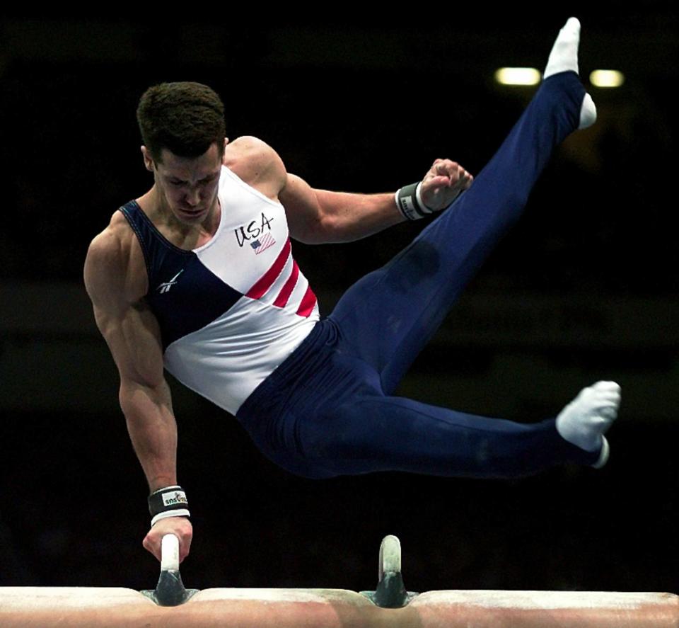 FILE - Team USA's John Roethlisberger performs his routine on the pommel horse during the men's all around competition at the Centennial Summer Olympic Games in Atlanta, in this Wednesday, July 24, 1996, file photo. The cutback in NCAA athletic programs due to the COVID-19 pandemic is being felt acutely in men's gymnastics. For decades Division I programs have produced an overwhelming majority of the US Olympic team. The number of Division I programs, however, is shrinking. The University of Minnesota and the University of Iowa will stop offering it as a scholarship sport at the end of the month. That will drop the number of Division I schools to 11. (AP Photo/Joe Cavaretta, File)