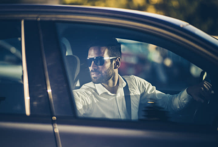 A guy looking back to reverse a car