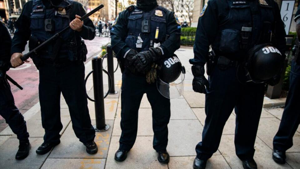 Members of the Metropolitan Police Department stand guard as they separate counter-protesters from supporters of President Trump near Black Lives Matter Plaza, on December 12, 2020 in Washington, DC. (Photo by Al Drago/Getty Images)