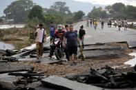 People walk among debris on a bridge over the Chamelecon river after the passage of Hurricane Eta, in Pimienta