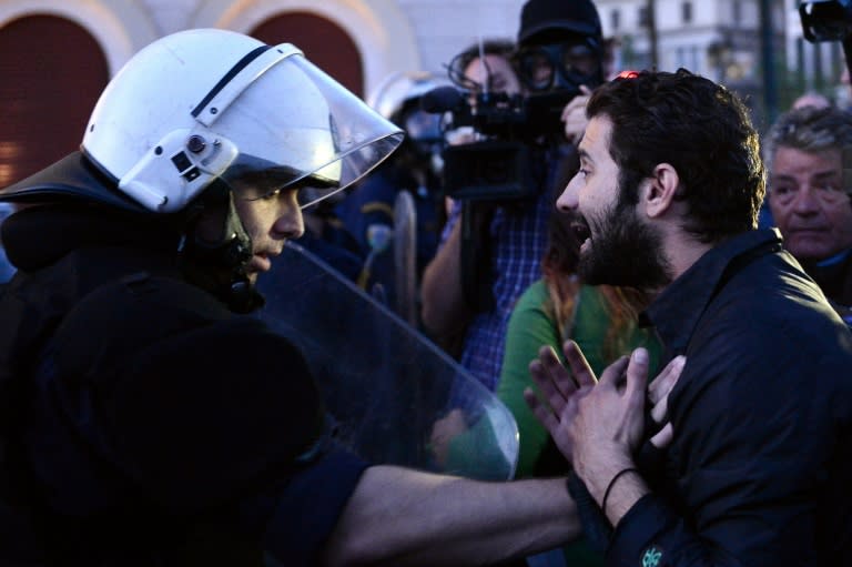 A protester (R) argues with a Greek policeman during a protest rally against the latest reform measures, in Athens on May 8, 2016