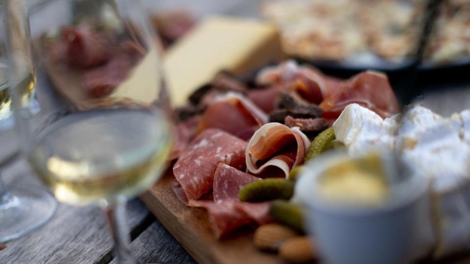 sliced charcuterie meat and cheese on a cutting boar