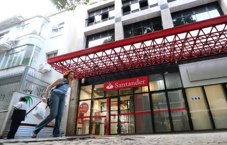 A woman walks past a Banco Santander branch in Rio de Janeiro