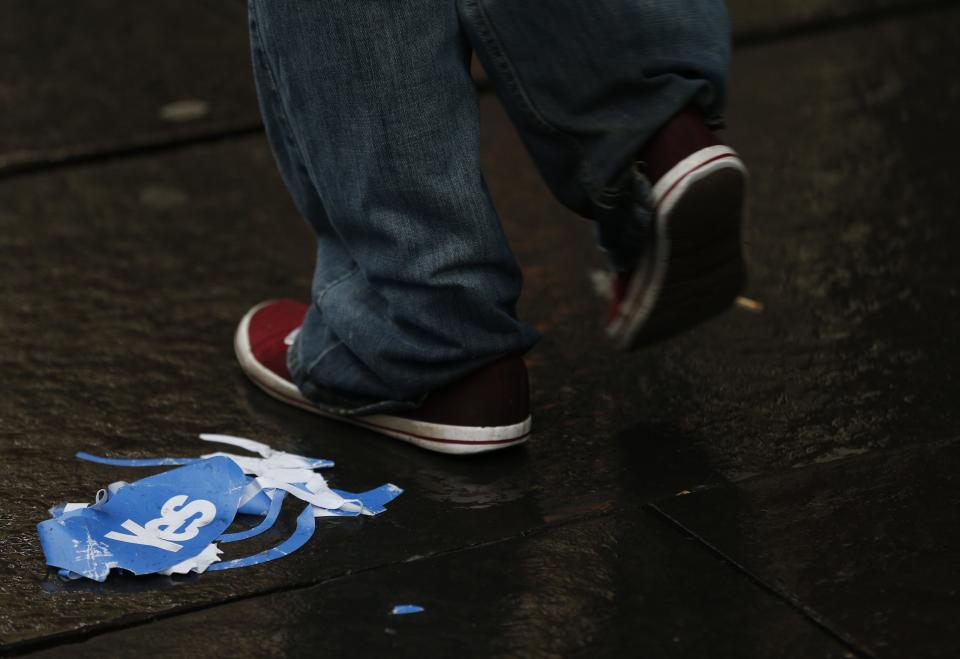 A man walks past a discarded "Yes" campaign paper hat on the Royal Mile after the referendum on Scottish independence in Edinburgh