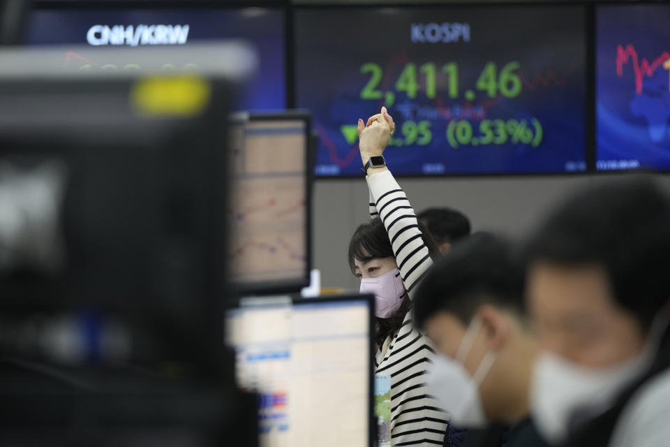 A currency trader stretches at the foreign exchange dealing room of the KEB Hana Bank headquarters in Seoul, South Korea, Thursday, Nov. 10, 2022. Asian stock markets followed Wall Street lower on Thursday ahead of a U.S. inflation update that will likely influence Federal Reserve plans for more interest rate hikes after elections left control of Congress uncertain.(AP Photo/Ahn Young-joon)