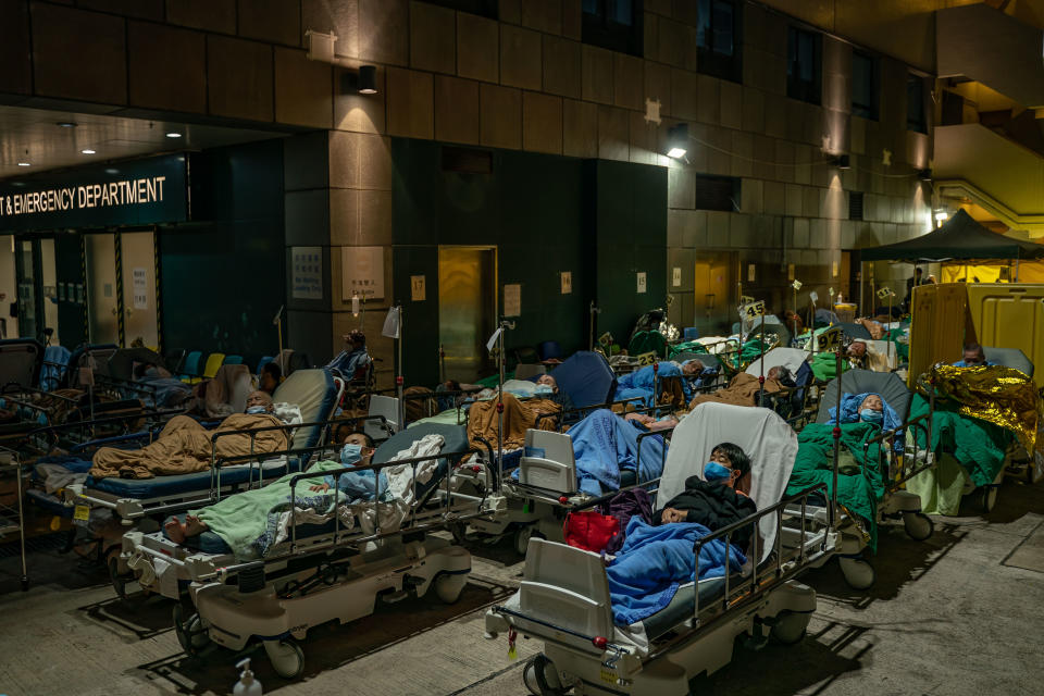 HONG KONG, CHINA - FEBRUARY 16: Patients lay in beds as they wait at a temporary holding area outside Caritas Medical Centre on February 16, 2022 in Hong Kong, China.  Health authorities confirm a new daily record of 4285 infections while near a record high of 7000 people tested preliminary positive. At least 10,000 infected people are waiting to be admitted to Hong Kong hospitals as cases overwhelm the public health care system.(Photo by Anthony Kwan/Getty Images)