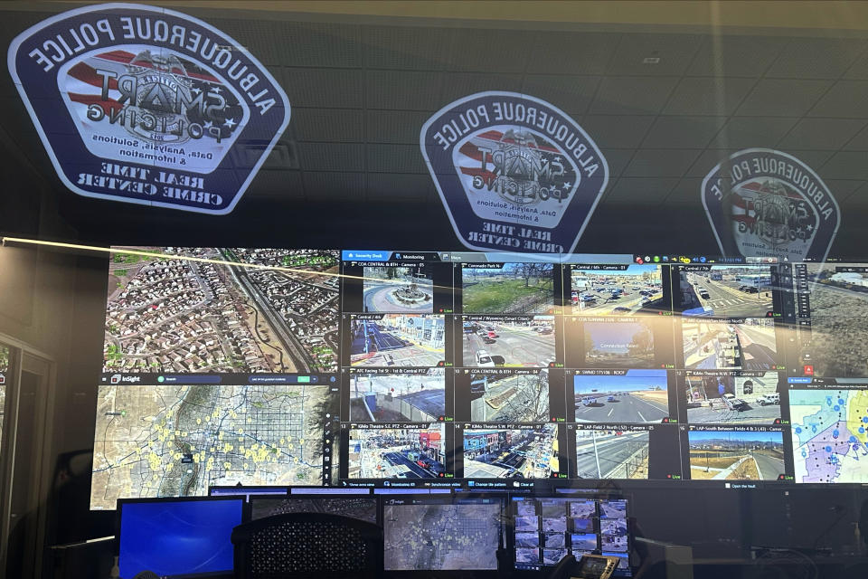 A wall of monitors behind a glass wall is pictured on Dec. 15, 2023, at the city's Real Time Crime Center in Albuquerque, N.M. Officials are seeking more funding from the New Mexico Legislature to add cameras and expand access to neighboring communities. (AP Photo/Susan Montoya Bryan)