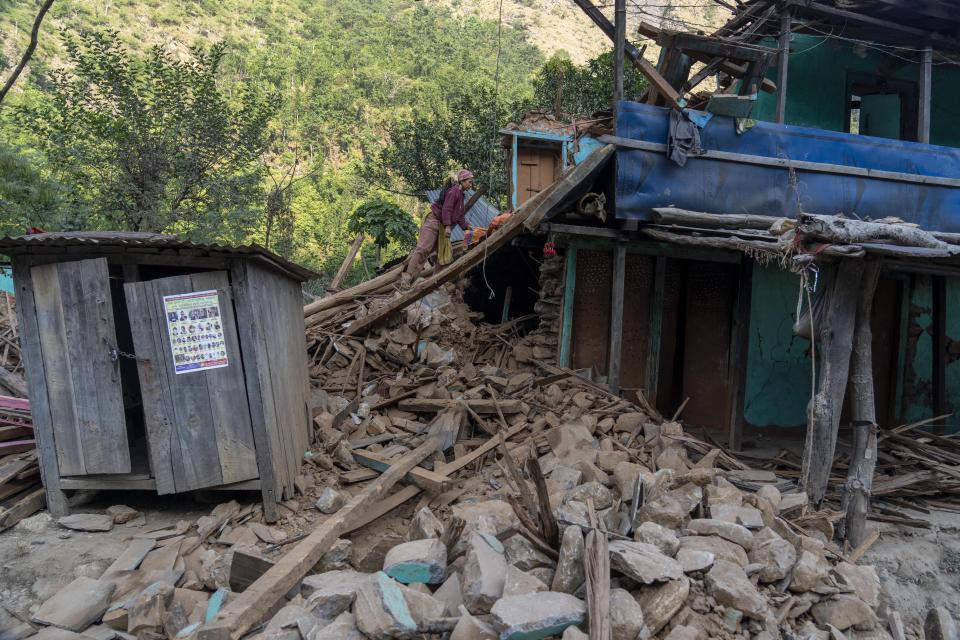 A survivor inspects an earthquake damaged house in Rukum District, northwestern Nepal, Monday, Nov. 6, 2023. The Friday night earthquake in the mountains of northwest Nepal killed more than 150 people and left thousands homeless. (AP Photo/Niranjan Shrestha)