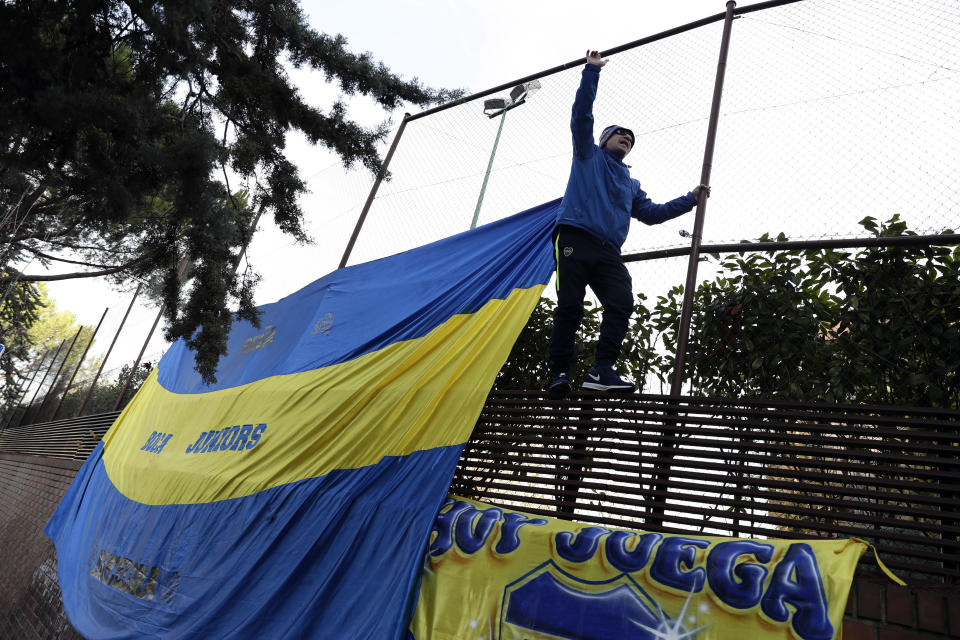 A Boca Juniors supporter climbs on a fence during a gathering of fans outside the team hotel in Madrid Saturday, Dec. 8, 2018. The Copa Libertadores Final between River Plate and Boca Juniors will be played on Dec. 9 in Madrid, Spain, at Real Madrid's stadium. (AP Photo/Manu Fernandez)