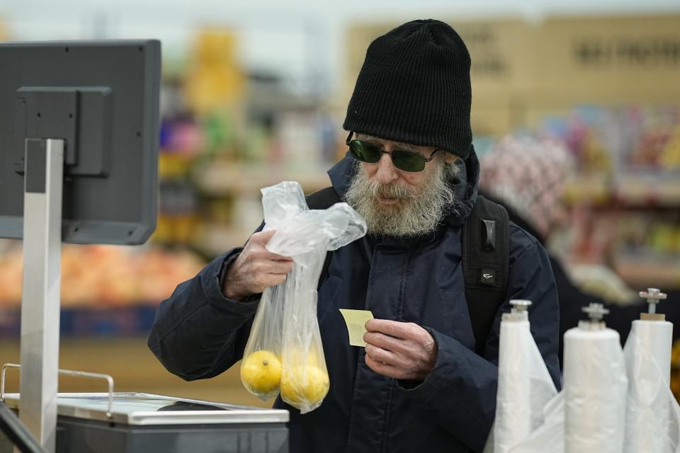 FILE - An elderly man buys fruit at a hypermarket in Moscow, Russia, on Nov. 3, 2023. The shelves at Moscow supermarkets are full of fruit and vegetables, cheese and meat. The economy's resilience in the face of bruising Western sanctions is a major factor behind President Vladimir Putin's grip on power in Russia. (AP Photo, File)