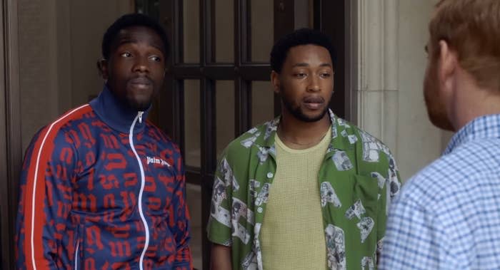 Two stylish young men stare incredulously at an unwanted visitor