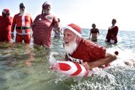 <p>Actors dressed as Santa Claus take a refreshing bath at Bellevue Beach north of Copenhagen, Denmark, on July 24, 2018, as they take part in the World Santa Congress, an annual two-day event held every summer in Copenhagen. (Photo: Mads Claus Rasmussen/Ritzau Scanpix/AFP/Getty Images) </p>