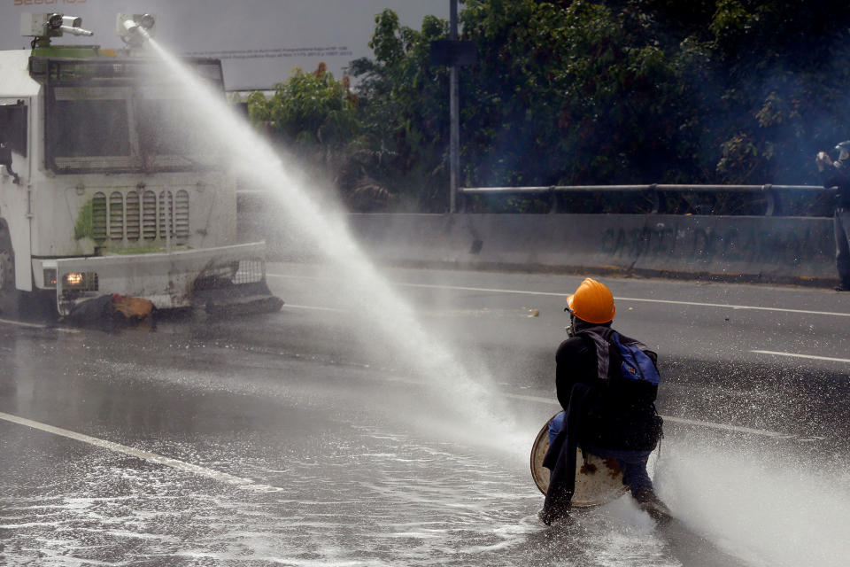 <p>A demonstrator confronts a police water cannon vehicle during a rally called by health care workers and opposition activists against Venezuela’s President Nicolas Maduro in Caracas, Venezuela, May 22, 2017. (Marco Bello/Reuters) </p>