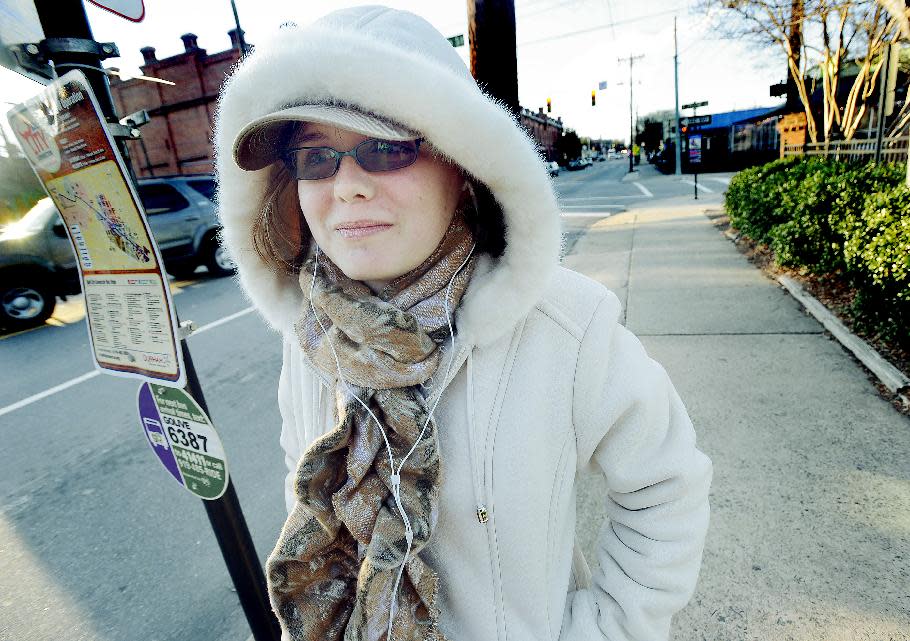 Clare Szigethy bundles up in the cold while waiting for the bus, downtown Durham, NC., Monday Jan. 6, 2014. The National Weather Service had much of North Carolina under a wind-chill warning and record-low temperature. (AP Photo/The Herald-Sun, Bernard Thomas)