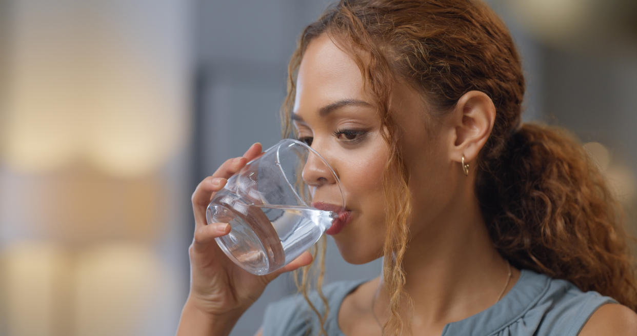 A woman drinks from a water bottle