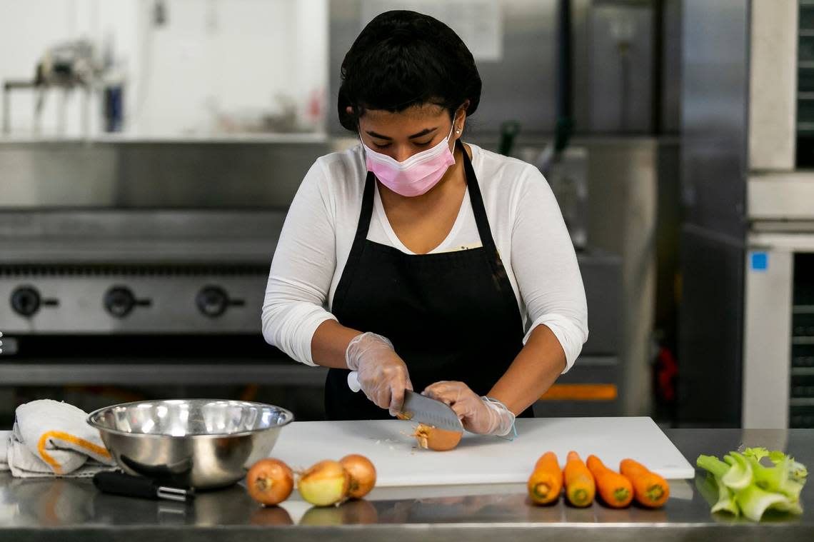 Emily Garcia, 21, cuts onions while participating in Feeding South Florida’s culinary training program in Boynton Beach, Florida on Wednesday, May 5, 2021.