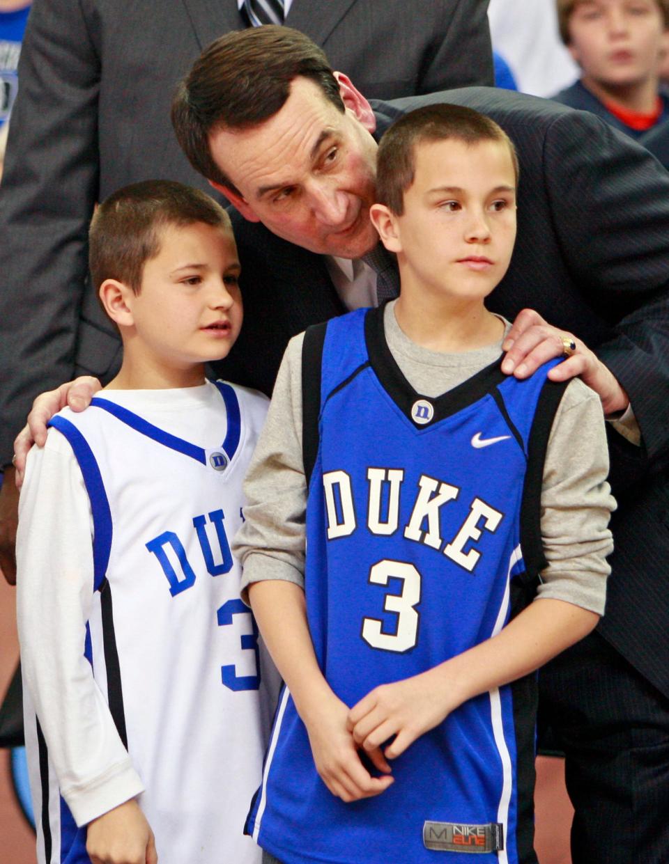 Mike Krzyzewski talks to his grandchildren Michael Savarino, in white jersey, and Joey Savarino after an NCAA championship college basketball game at the Atlantic Coast Conference men's tournament in Atlanta, Sunday, March 15, 2009.  Duke defeated Florida State 79-69 for the ACC championship. (AP Photo/John Bazemore)