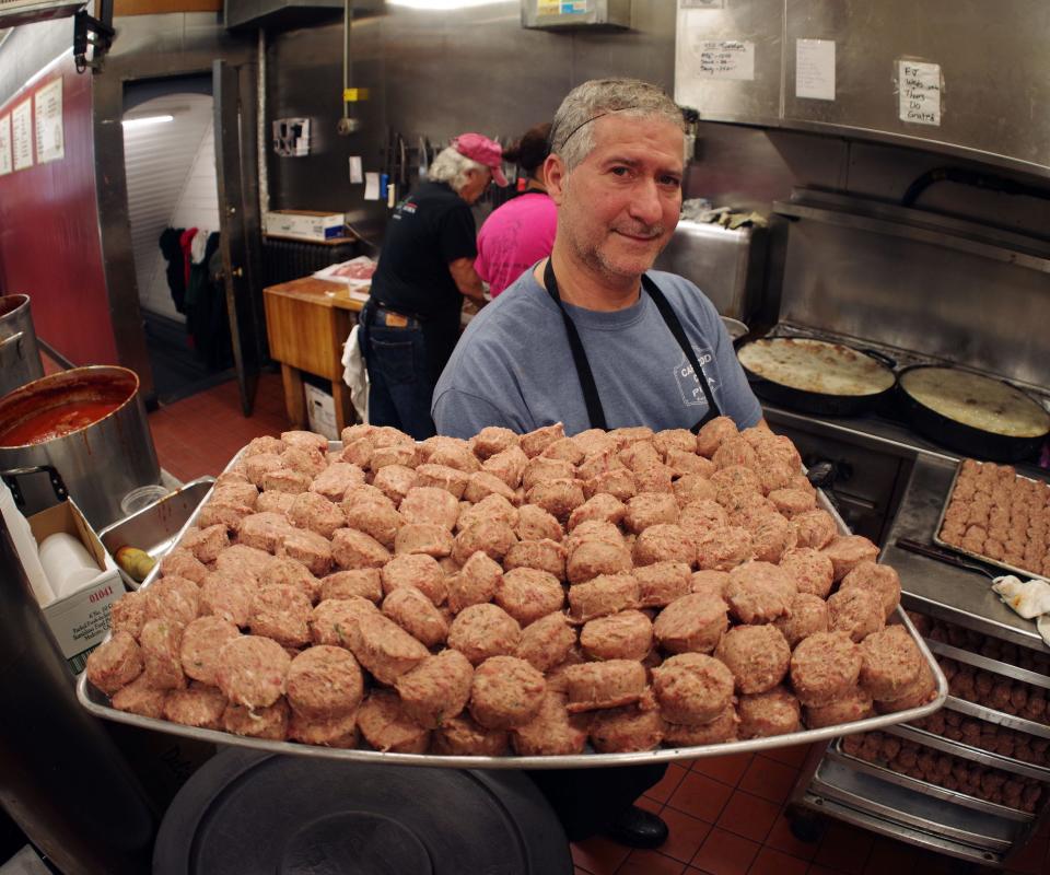 Josue Da Cunha of the Italian Kitchen in Brockton takes a tray of fresh meatballs and takes them to the fryer on Thursday, Dec. 28, 2023.