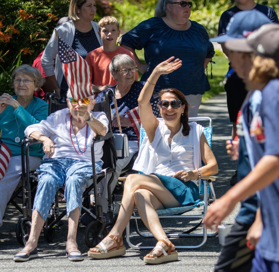 Sandra Huber, 87, waves the American flag while Tish Whitney waves to the people in the Fourth of July parade on Monday in Sandwich.