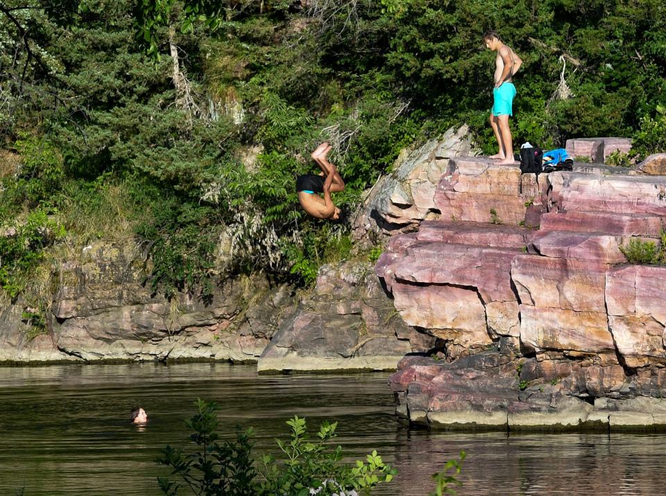 Marcus Anthony flips into the water of Split Rock Creek while swimming with friends Jacob Docter and Jackson Adams at Palisades State Park on Wednesday, July 20, 2022, in South Dakota.