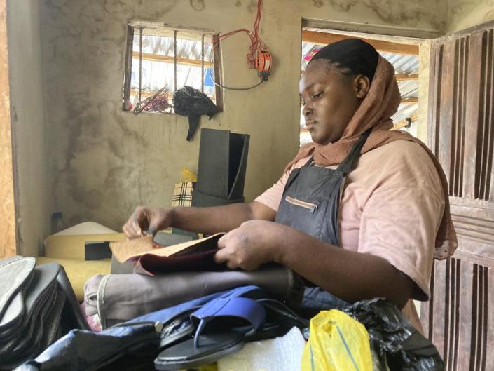 Amidat Ahmed, a 22-year-old economics student at University of Abuja, learns how to make shoes following a university strike in Abuja, Nigeria, Wednesday Aug. 10, 2022. (AP Photo/Chinedu Asadu)