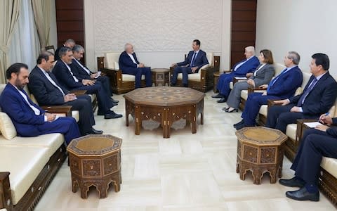 Syrian President Bashar al-Assad, centre right, meets with Iranian Foreign Minister Mohammad Javad Zarif in Damascus, Syria on Monday, - Credit: SANA