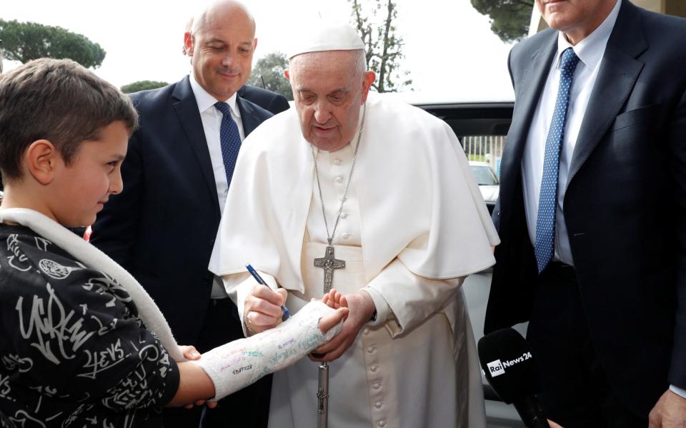 The Pope signed a boy's cast as he left the hospital - REMO CASILLI/REUTERS