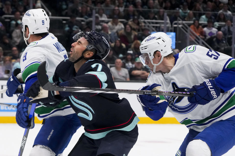 Vancouver Canucks defenseman Tyler Myers, right, high-sticks Seattle Kraken right wing Jordan Eberle during the first period of an NHL hockey game Friday, Nov. 24, 2023, in Seattle. (AP Photo/Lindsey Wasson)