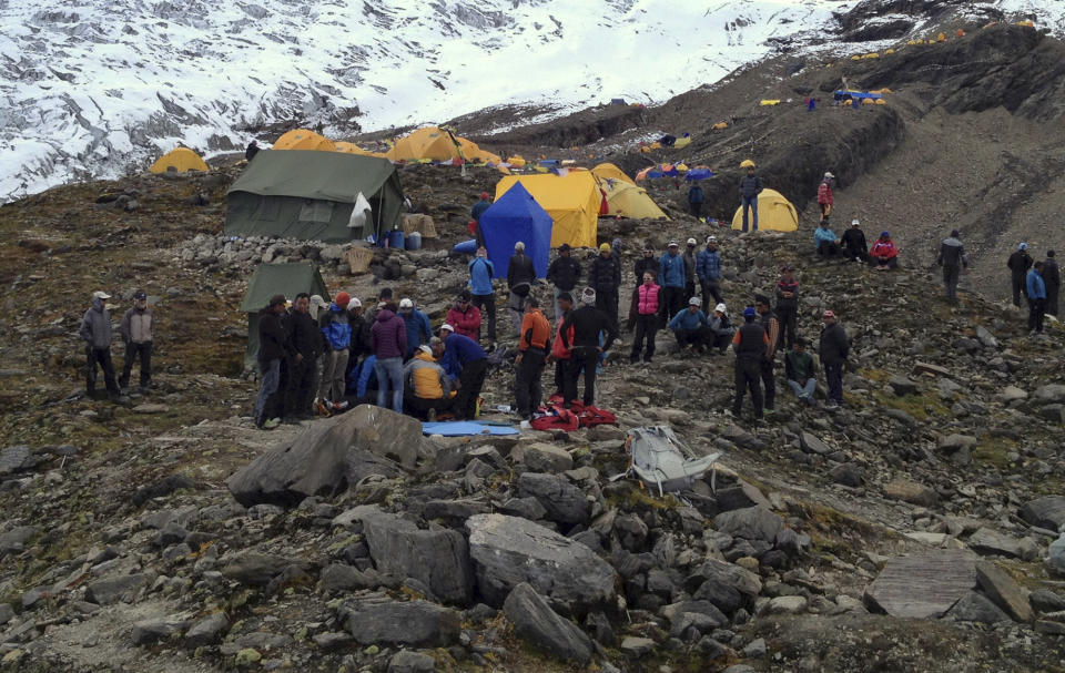 In this photo provided by Nepalese airline Simrik Air, rescuers attend to injured victims, unseen, after an avalanche at the base camp of Mount Manaslu in northern Nepal, Sunday, Sept. 23, 2012. The avalanche swept away climbers on a Himalayan peak in Nepal on Sunday, leaving at least nine dead and six others missing, officials said. (AP Photo/Simrik Air)