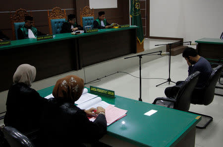 An Indonesian man sits in an Islamic court, one of the two men sentenced to 85 lashes of the cane for having sex together, in Banda Aceh, Aceh province, Indonesia May 17, 2017. REUTERS/Junaidi Hanafiah