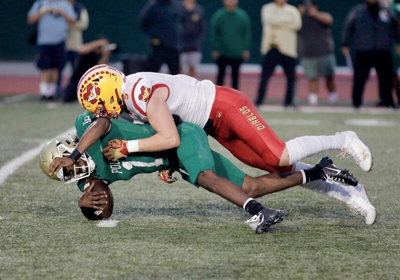 Mission Viejo defensive end Jaden Williams sacks Poly quarterback Darius Curry in the first quarter Friday night.