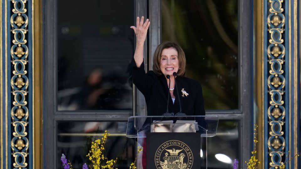 Rep. Nancy Pelosi raises her hand in the air during her remarks at Feinstein's funeral.  - Godofredo A. Vásquez/AP
