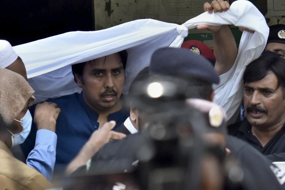 Police officers escort Shahbaz Gill, center in blue shirt, a political aide to former Pakistani prime minister Imran Khan, after a court appearance, in Islamabad, Pakistan, Monday, Aug. 22, 2022. Police arrested Gill earlier this month after he appeared on the private television channel ARY TV and urged soldiers and officers to refuse to obey “illegal orders” from the military leadership. Gill was charged with treason, which carries the death penalty under Pakistan's sedition act that stems from a British colonial-era law. (AP Photo)