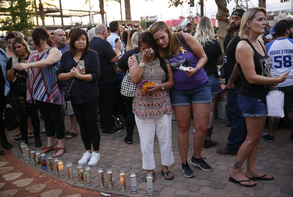 People embrace before a ceremony at a memorial garden, Monday, Oct. 1, 2018, on the anniversary of the mass shooting a year earlier, in Las Vegas. (AP Photo/John Locher)