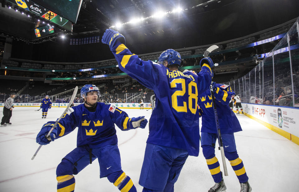 Sweden's Oskar Magnusson (28) celebrates a goal against Germany with Victor Stjernborg (19) and Linus Sjodin (18) during the first period of an IIHF world junior hockey championships game Monday, Aug. 15, 2022, in Edmonton, Alberta. (Jason Franson/The Canadian Press via AP)