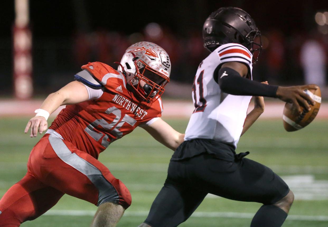 Connor Satterfield, 25, of Northwest prepares to bring down Stevie Diamond, 11, of Buchtel during their DIV regional quarterfinal at Northwest on Friday, Nov. 4, 2022.