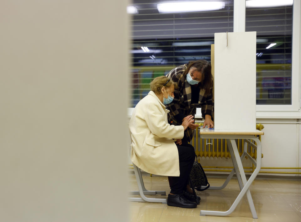 A woman prepares her ballot for a presidential election at a poling station in Ljubljana, Slovenia, Sunday, Oct. 23, 2022. Voters in Slovenia on Sunday cast ballots to elect a new president of the European Union nation, with three main contenders leading the race but no clear winner in sight. (AP Photo)