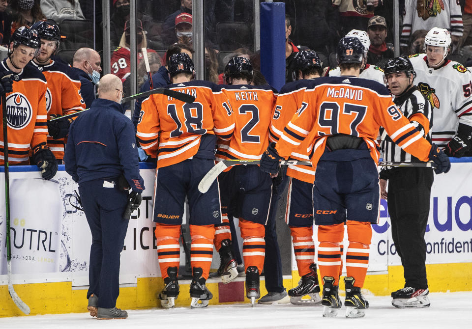 Edmonton Oilers' Duncan Keith (2) is helped off the ice after being injured during the first period of the team's NHL hockey game against the Chicago Blackhawks on Wednesday, Feb. 9, 2022, in Edmonton, Alberta. (Jason Franson/The Canadian Press via AP)