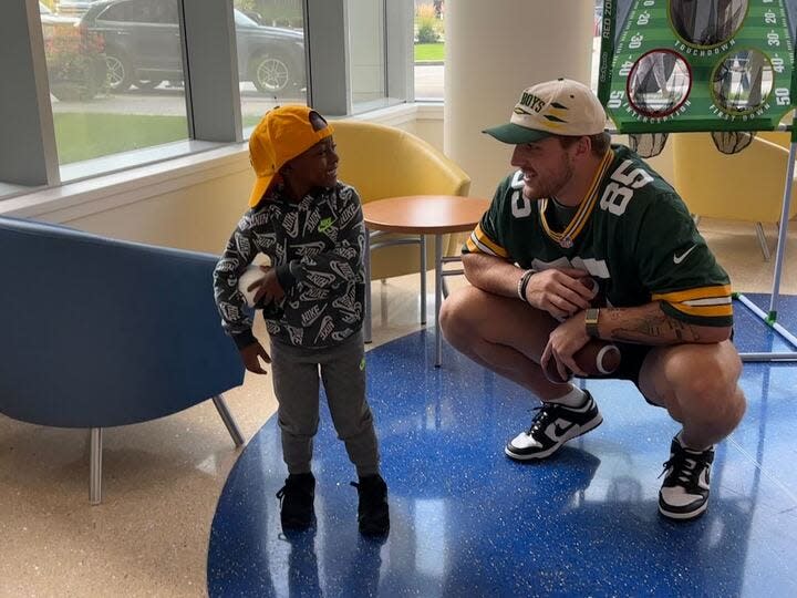 The Packers' Tucker Kraft laughs with a young boy at Children's Wisconsin Milwaukee Hospital on Tuesday.