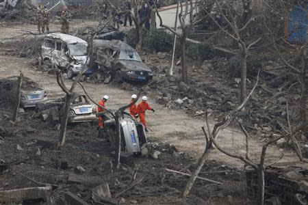 Rescuers search for survivors on a damaged road covered with debris after an explosion in a Sinopec Corp oil pipeline in Huangdao, Qingdao, Shandong Province November 23, 2013. REUTERS/Aly Song