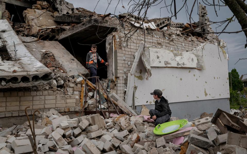 Dmytro, 8, left, walks through the rubble of his destroyed home with his friend Andri, 11, in the village of Novoselivka, on the northeastern side of Chernihiv, Ukraine - Nicole Tung/The New York Times