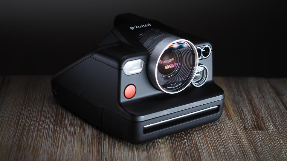 Polaroid I-2 camera on a wooden surface with dramatic lighting