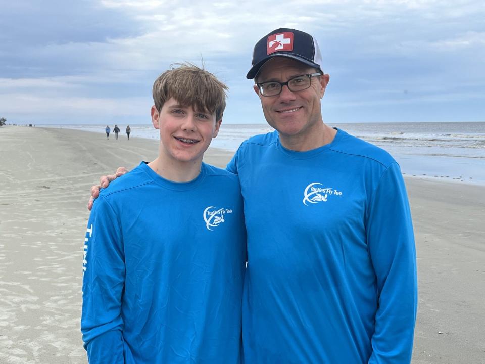 Steven Bernstein, a volunteer pilot with Turtles Fly Too, shares a moment with his 14-year-old son Owen after 35 turtles were released into the ocean from Jekyll Island.