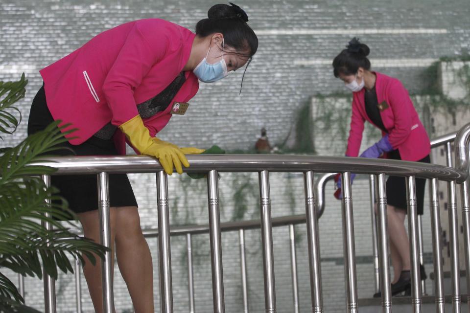 Restaurant staff, wearing face mask, disinfect the handrail of Chongchun Restaurant in Pyongyang, on Thursday, May 13, 2021. (AP Photo/Cha Song Ho)