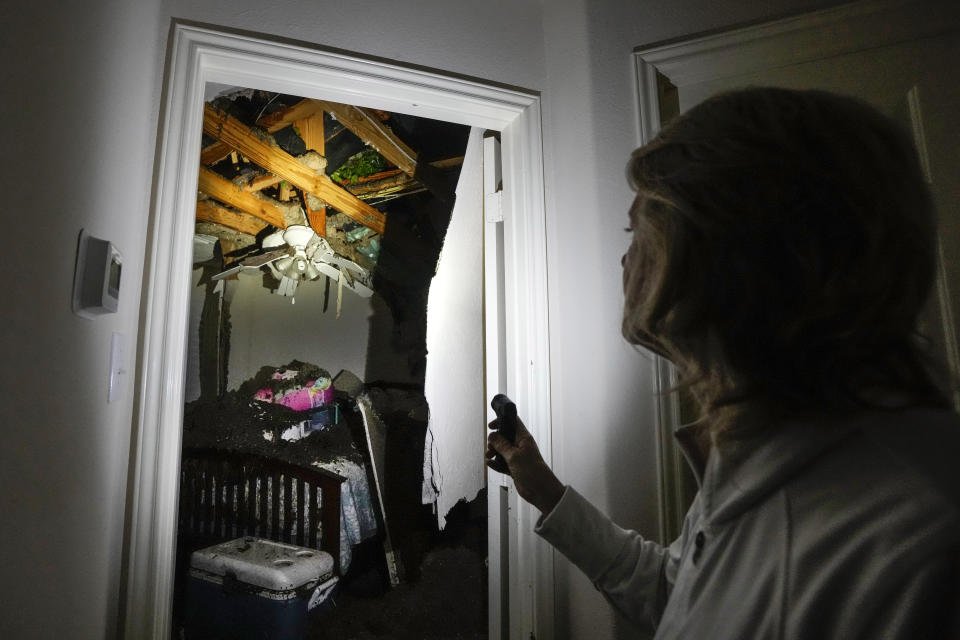Monica Pease surveys the damage to her home after four trees fell on it during a severe storm, Thursday, May 2, 2024, in Spring, Texas. (Brett Coomer/Houston Chronicle via AP)
