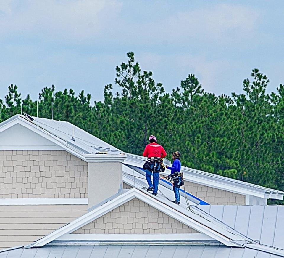 Construction workers scale a roof of a building under construction in the SilverLeaf development in St. Johns County in this 2020 photo.