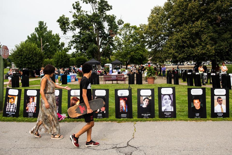 People read the stories of those remembered on posters at the Black Poster Project at Crane Park in Monroe on August 7, 2021.