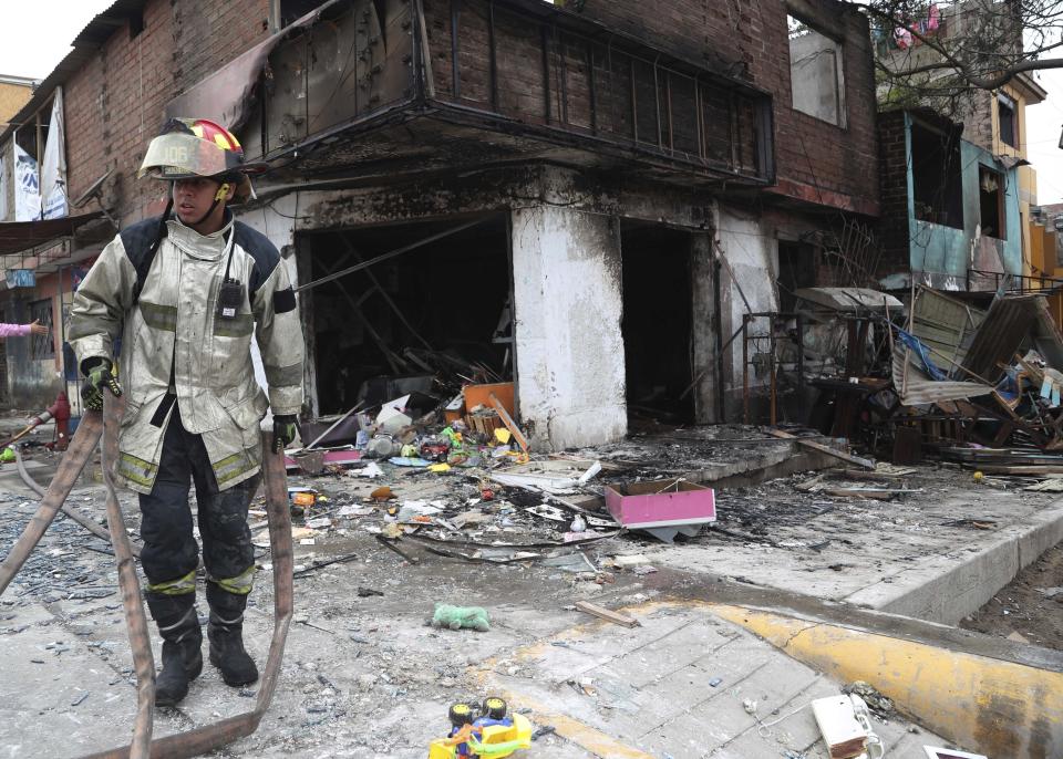 Un bombero cambia de posición después de rociar agua en una casa cercana al lugar donde explotó un camión de gas en el barrio de Villa María en Lima, Perú, el jueves 23 de enero de 2020. Un camión cisterna de gas natural explotó en ese área urbana del sur de Lima y dejó dos muertos, unas 50 personas heridas y al menos una docena de casas quemadas. (AP Foto / Martín Mejía)